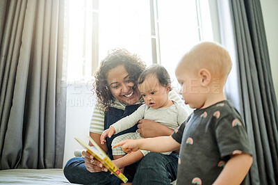 Buy stock photo Mother, babies and learning with book in home, storytelling and education in house. Development, care and happy mama or babysitter reading with children, kids or toddlers while bonding and having fun