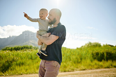 Buy stock photo Baby, pointing and father walking in a field, happy and bonding in nature with love. Hug, carrying and parent with child in the countryside for fun, travel and vacation, walk and learning in Mexico