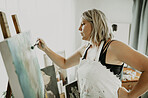 Woman, painting and creative art in studio, home or house with brush, paint and canvas. Artist person and relax painter with talent for design in workshop