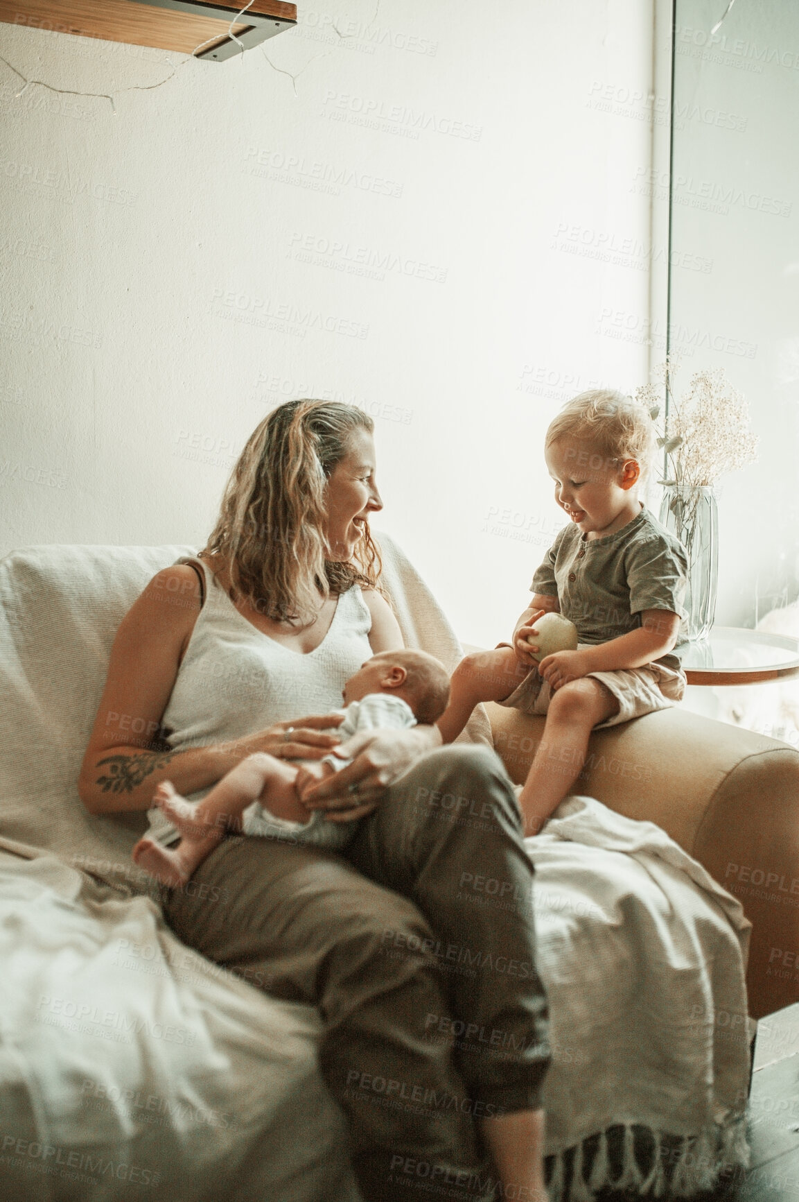 Buy stock photo Love, bonding and mom with her toddler and baby relaxing on sofa in the living room of their home. Happy, sweet and young mother talking to her infant and newborn child with childcare in family house