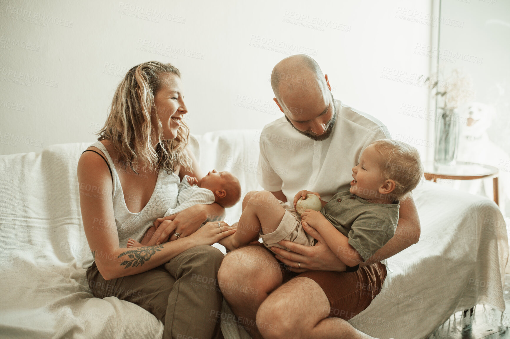 Buy stock photo Parents, children and a playful bonding on the sofa in the living room of their home together for fun. Mother, father and kids in the house with a baby and cute boy child laughing in the lounge