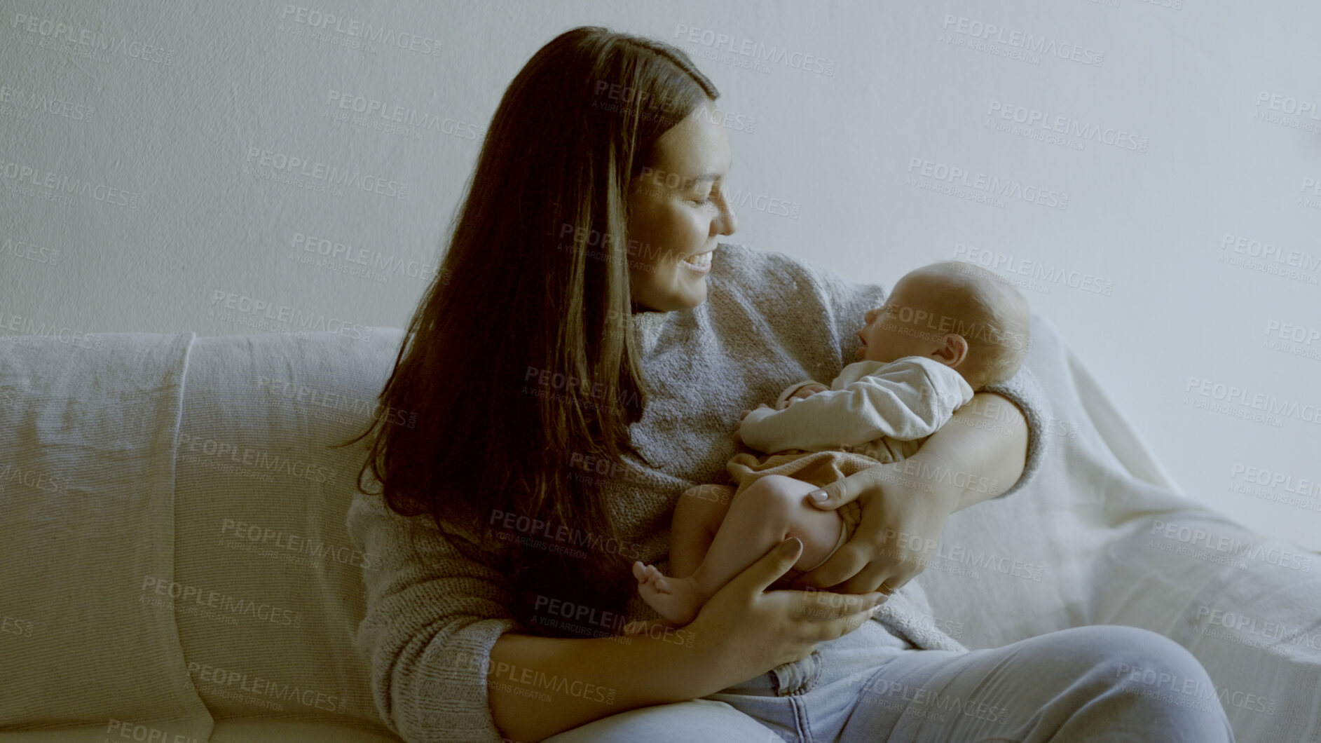 Buy stock photo Happy, smile and mother with her baby on a sofa for relaxing, bonding and resting in living room. Love, care and young mom holding her infant, newborn or child with happiness in lounge of family home