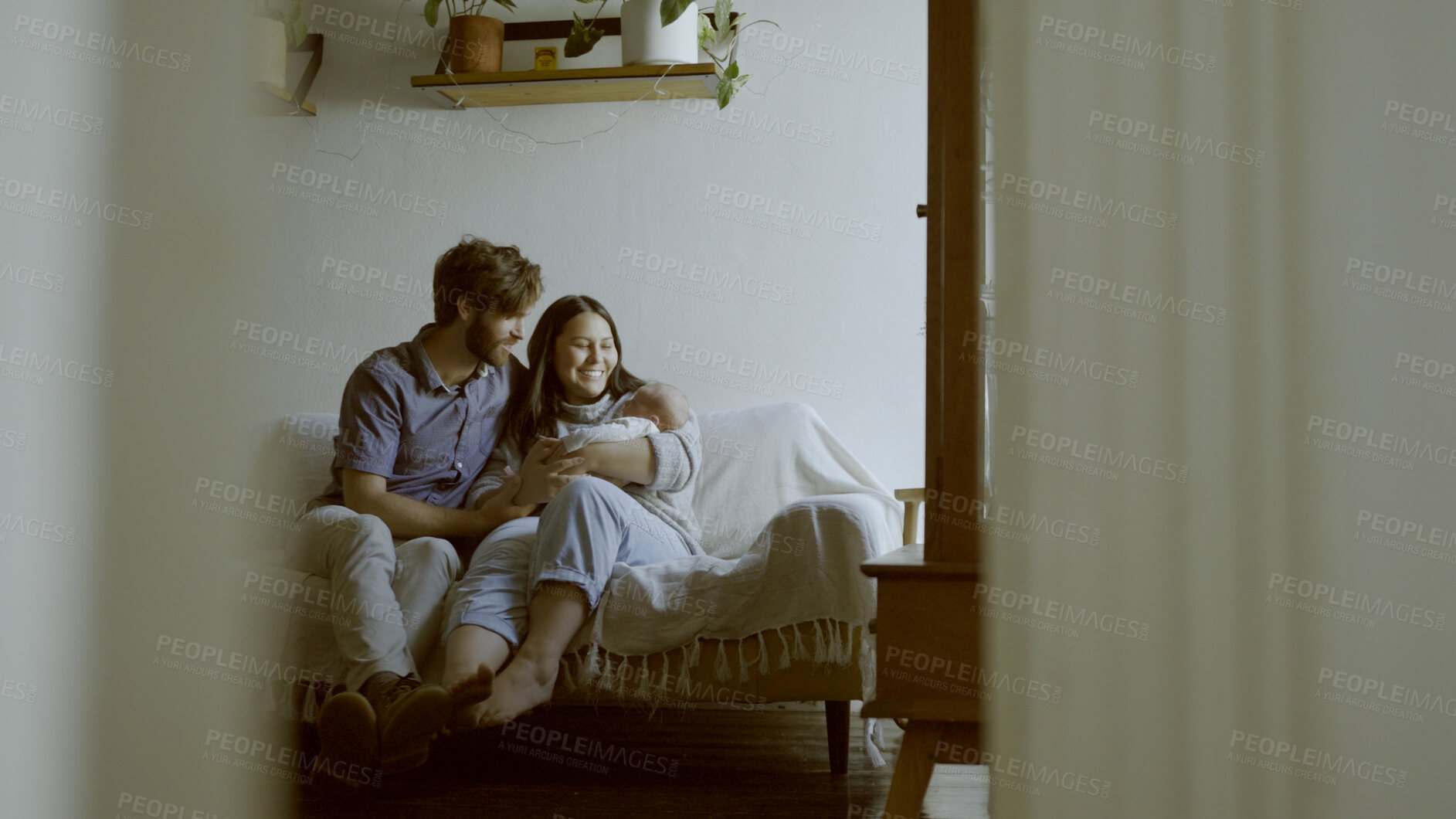 Buy stock photo Family, parents and baby on a sofa in the living room of their home together for love, care or bonding. Mother, father and relax with happy people holding their cute newborn infant chid in a house