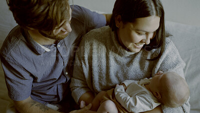 Buy stock photo Mother, father and baby as a family in the living room of their home together for love, care or bonding. Family, smile and relax with happy parents holding their cute newborn infant chid on a sofa