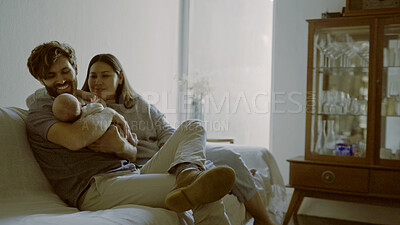 Buy stock photo Mother, father and baby on a sofa as a family in the living room of their home together for love, care or bonding. Relax, happy or smile with parents holding their cute newborn infant chid in a house