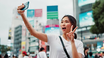 Buy stock photo Japanese woman, selfie and peace sign in city with live streaming of vlogger for content creation. Video, social media and profile picture in Tokyo with travel, vacation and app with post and website