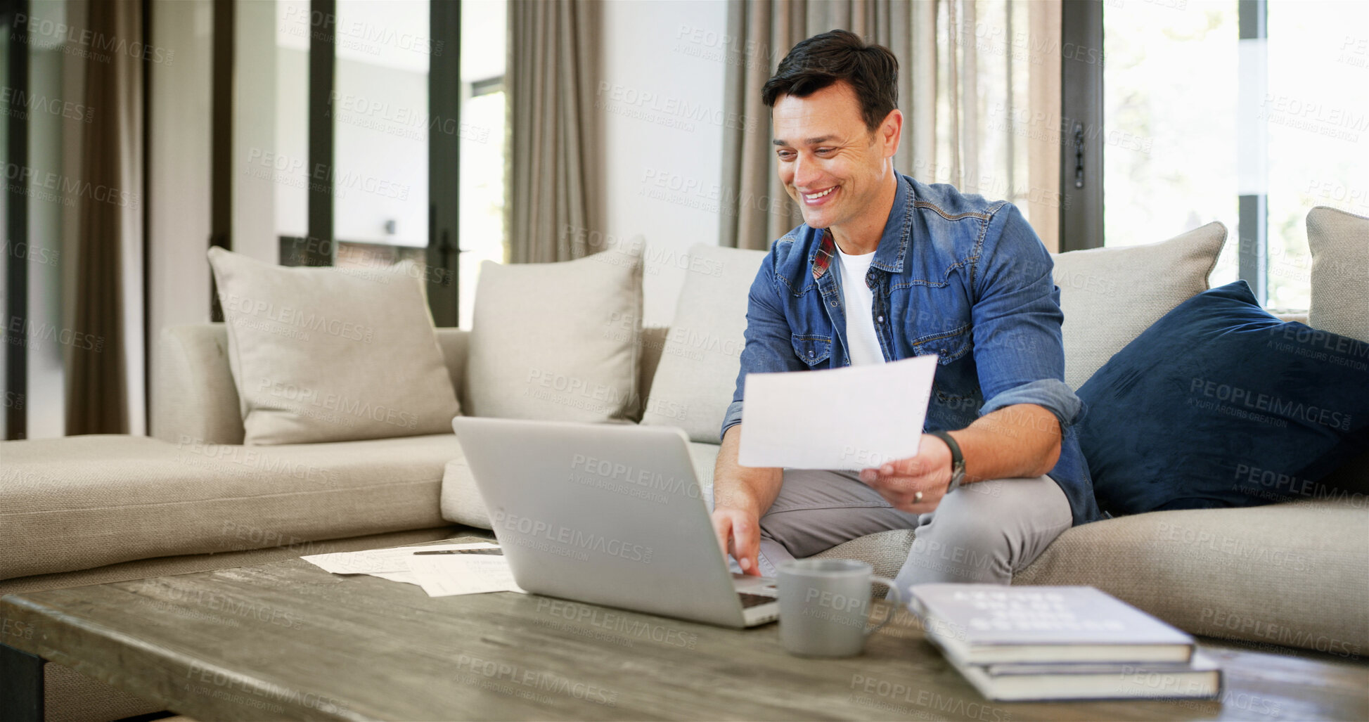 Buy stock photo Home, man and laptop with paperwork for finance, track expenses and success for budget goal on sofa. House, male person and happy with documents for payment review, digital savings and mortgage bills