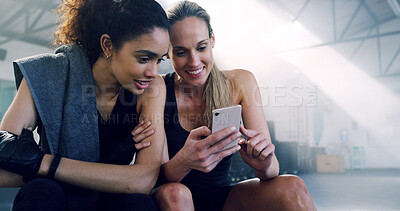 Buy stock photo Women, smartphone and friends in gym, exercise and internet with online reading for fitness schedule. People, girls and athletes in wellness center, mobile user or cellphone with social media and app