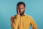 Stress, tired and black man with headache in studio, tension or pressure on blue background. African person, burnout or model with migraine, illness or frustrated with brain fog, pain and fatigue