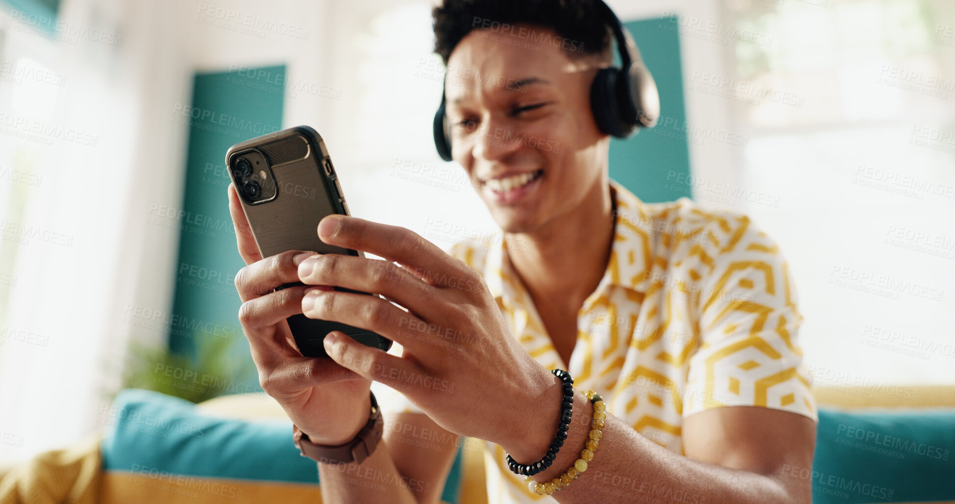 Buy stock photo Phone, headphones and hands in home with music, podcast and listening to jazz album on radio to relax on sofa. Mobile, happy man and streaming sound, audiobook and scroll social media app on internet