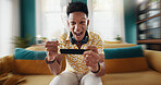 Excited man, portrait or winning race with phone for esport competition or mobile gaming on sofa at home. Happy, male person or gamer with victory or rank for speed simulation or virtual championship