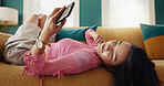 Mobile, relax and woman in home, reading text and content creator post on social media profile on internet. Phone, sofa and girl on chat app for communication, check notification and ebook to chill