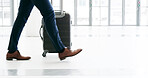 Business, suitcase and walking with person in airport terminal for international travel or trip. Legs, luggage and flight with corporate passenger at arrival or departure gate for boarding or journey