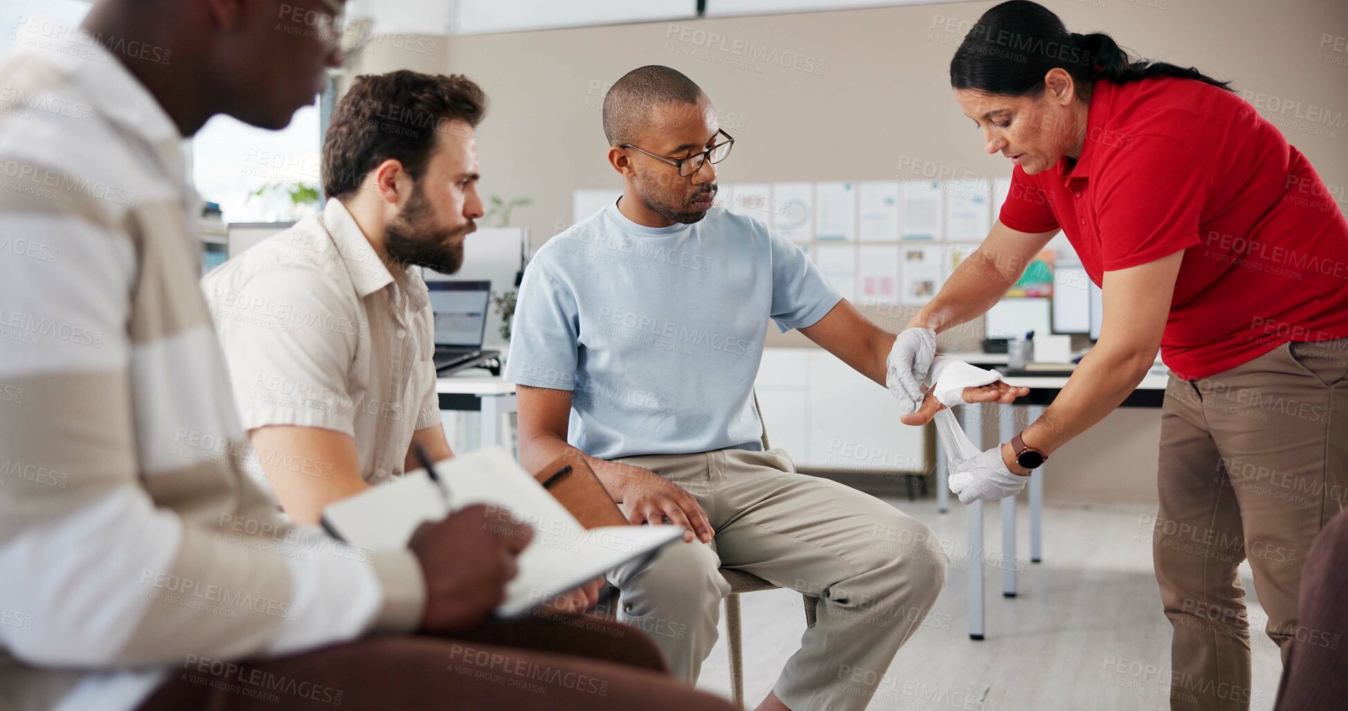 Buy stock photo Woman, men and first aid with bandage, teaching or course with notes, attention or help at office. Paramedic, coach and staff with books for treatment, wound or burn injury with training in workplace