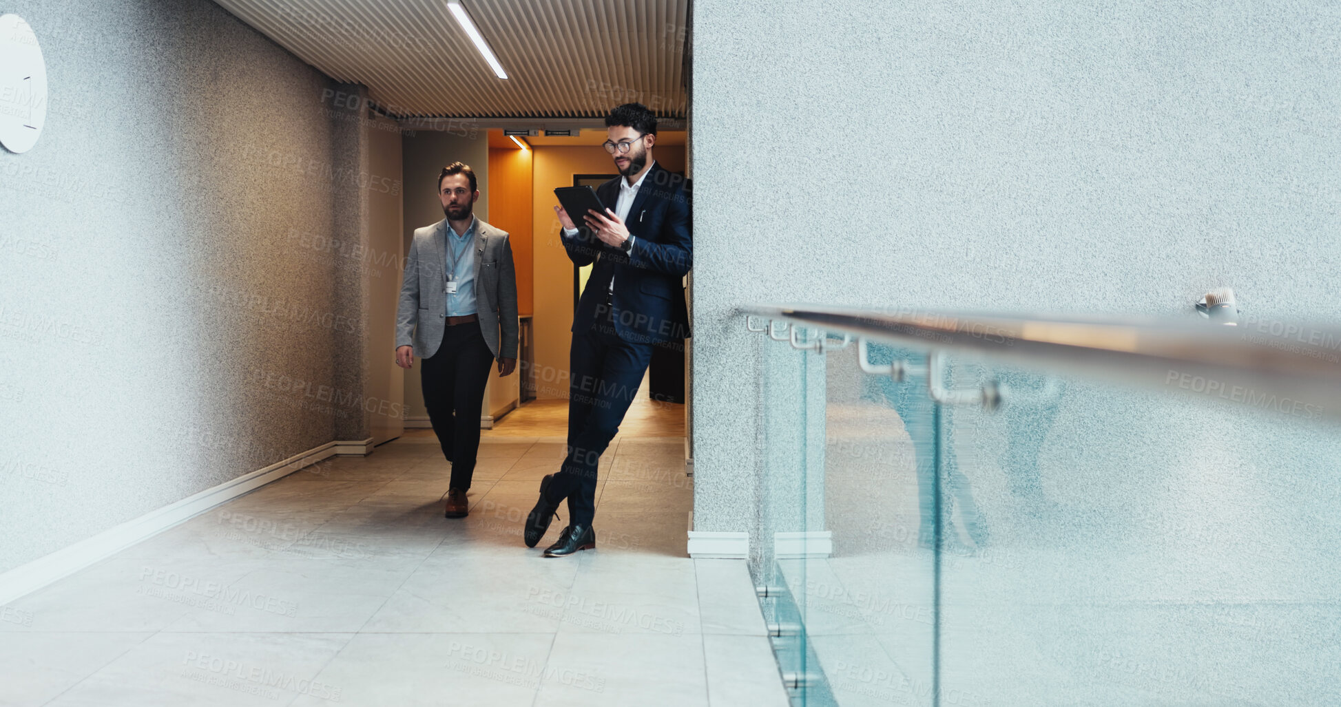 Buy stock photo Man, tablet and walking with business people in corridor of corporate office for planning or research. App, busy and social media with employee men colleagues in agency or professional workplace