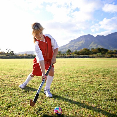 Buy stock photo Girl, green grass and playing hockey for game, outdoor match or sports in nature for practice. Female person, kid or playful child enjoying competition with ball on field for fitness or training