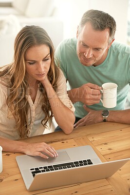 Buy stock photo Laptop, home planning and couple reading or scroll on internet together for online, website or application at table. Mature partner, woman or people on computer or pc, coffee or tea in the morning