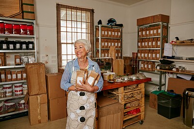 Buy stock photo Cropped shot of a senior woman holding bags of coffee beans while standing in a roastery