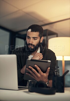Buy stock photo Design, laptop and tablet with programmer man in office at night for coding or computer engineering. Creative, research and thinking with employee at desk in tech workplace for project deadline