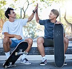 High five, skateboard and skater friends at city skatepark, young men sitting in concrete park and celebration of achievement. Freedom, urban fun and happy gen z men hands celebrate skate trick goals