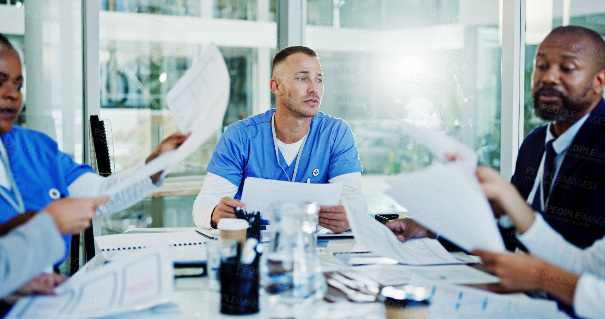 Buy stock photo Doctors, nurses and man in meeting with paperwork for hospital management, funding or planning in busy office. Teamwork, group and people in conference room for medical collaboration in healthcare