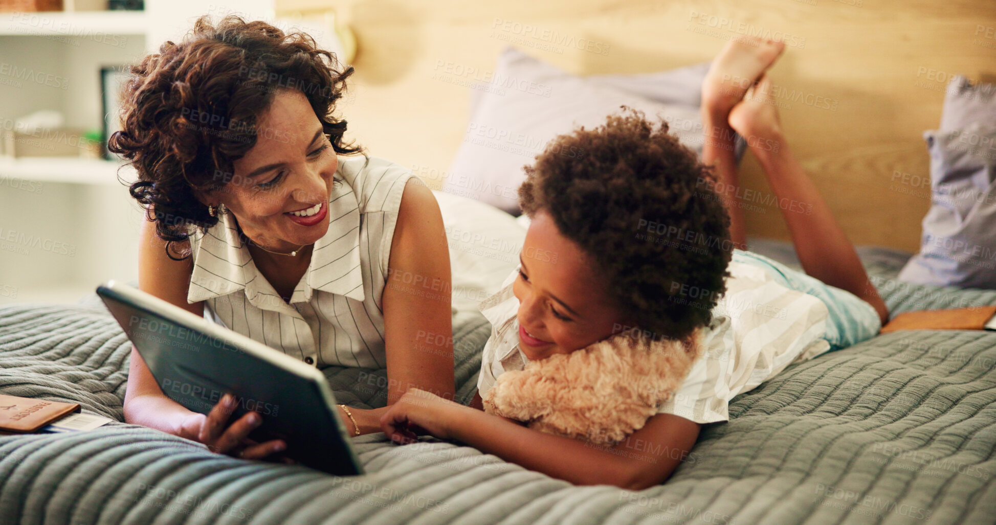 Buy stock photo Woman, child and relax on bed with tablet, streaming media or show educational video in home. Mother, kid or tech in bedroom for bonding, interactive learning app or browse toy website for teddy bear