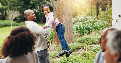 Buy stock photo Father, daughter and playing in backyard by home for lifting game, bonding together and fun at family gathering. People, happy and man swinging child in garden for support, trust and freedom by house