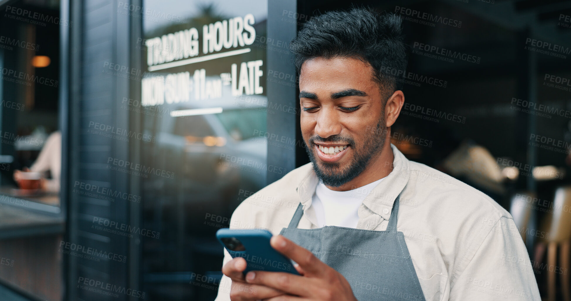 Buy stock photo Man, waiter and outdoor cafe with phone, social media break and communication at coffee shop. Texting, hospitality service and male person online by restaurant front door, reading message and chat