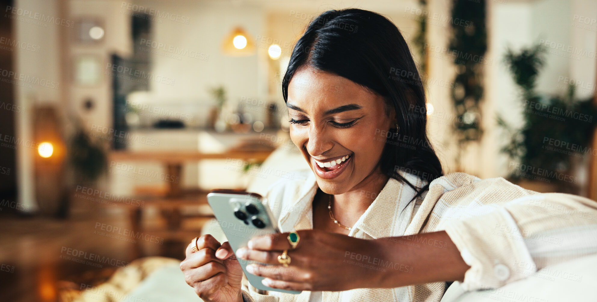 Buy stock photo Woman, phone and laughing with texting on sofa in home, chat and funny meme in living room. Girl, person and smile with mobile app, contact and comic video on social media in lounge at apartment