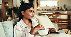 Woman, watching tv and popcorn on sofa in home with smile, relax and streaming for film award show in lounge. Girl, person and happy with snack, movies or subscription in living room at apartment