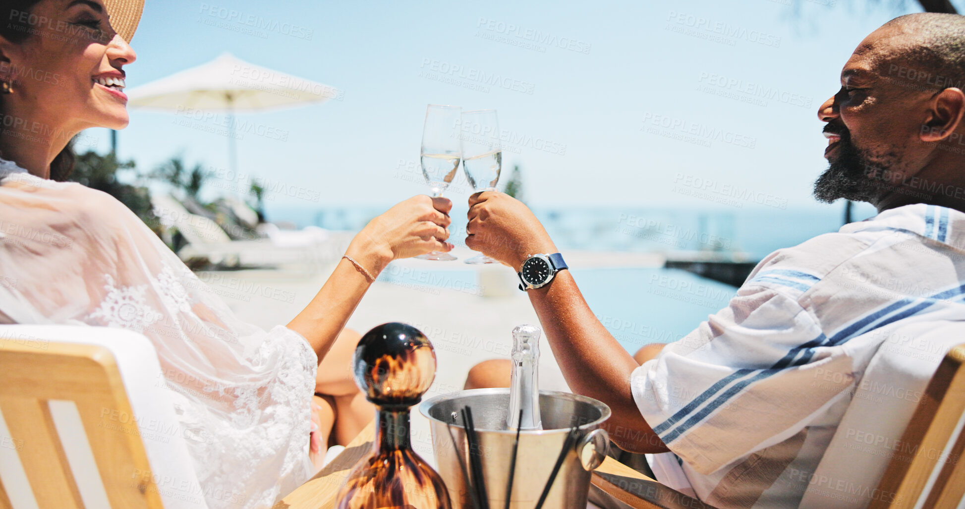 Buy stock photo Couple, toast champagne and happy on patio, relax or view by ocean, celebration or cheers on valentines day. Mature people, man and woman for interracial love, drinks or holiday on balcony by sea