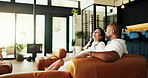 Interracial couple, happy and laugh on sofa in home with funny story, gossip or together with memory in living room. Mature people, man and woman with love with talk, joke and relax on valentines day