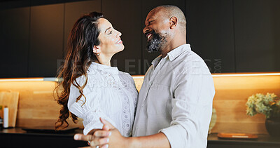 Buy stock photo Happy, interracial couple or holding hands with dance for love, romance or bonding together in kitchen at home. Mature man, woman or lovers with smile for weekend, sway or romantic steps at house