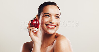 Buy stock photo Happy woman, beauty and thinking with red apple in studio for makeup color, gloss or organic skincare on a white background. Face, female person or model with smile for fruit, skin glow or vitamins