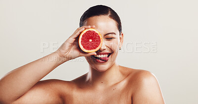 Buy stock photo Happy woman, beauty or skincare with grapefruit for detox or vitamin C on a white studio background. Female person, model or smile with tongue out for natural organic fruit, healthy skin or nutrition