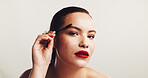 Beauty, girl or brush eyebrow in studio for makeup application, face transformation or portrait. Space, woman or mascara tool for facial hair shape, cosmetics or self care routine on white background