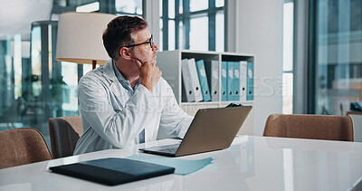 Buy stock photo Healthcare, laptop and thinking with doctor man at desk in office of hospital for diagnosis, planning or research. Computer, idea and medical with mature medicine professional in clinic for vision