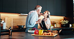 Cooking, mature couple and feeding of meal, kitchen or bonding with ingredients for cuisine in home. People, helping and taste of recipe for dinner, culinary skills or eating of healthy food in house