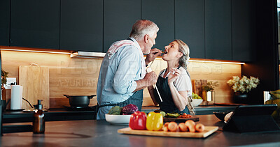 Buy stock photo Cooking, mature couple and feeding of meal, kitchen or bonding with ingredients for cuisine in home. People, helping and taste of recipe for dinner, culinary skills or eating of healthy food in house