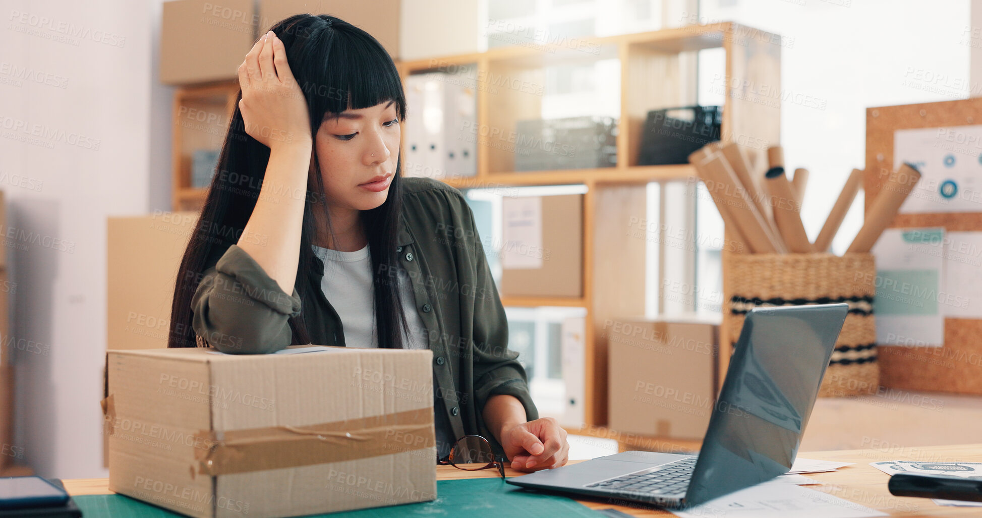 Buy stock photo Frustrated, asian woman and logistics with box on laptop for mistake, delivery cost or supplier issue at warehouse. Female person, distributor or employee with headache for shipping inflation or tax