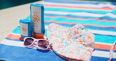 Buy stock photo Sunscreen, sunglasses and hat on towel at swimming pool for uv rays protection, spf cream and summer vacation. Sunblock lotion, dermatology product and hat outdoors at holiday resort for skincare