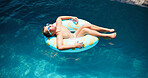 Child, swimming and boy on floater in pool for holiday, travel or outdoor vacation for tanning. Paradise, relax and male kid sunbathing in water at lodge, hotel or resort on summer break in Miami