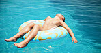 Child, swimming and boy on floating in pool for holiday, travel or outdoor vacation for tanning. Paradise, relax and male kid sunbathing in water at lodge, hotel or resort on summer break in Miami