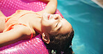 Happy girl, relax or lying with inflatable in swimming pool for summer holiday or vacation at luxury resort. Female person, child or kid with smile or comfort on floating toy for playful fun in sun