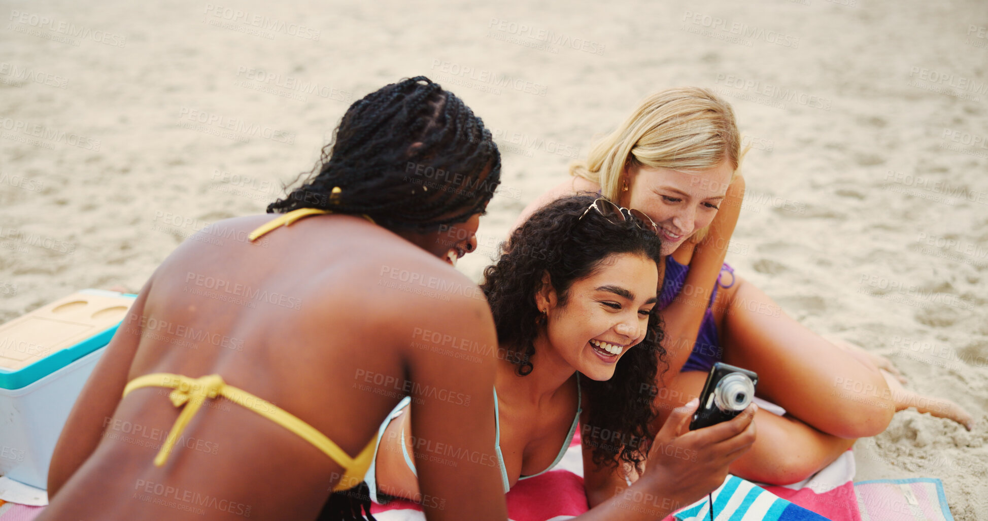 Buy stock photo Camera, women and friends at beach with smile, photoshoot or reunion for photography on holiday. Check, ocean or happy people bonding together on break for picture, fun memory or diversity at sea