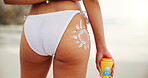 Bikini, butt and sunscreen with woman on beach from back for holiday, travel or vacation. Behind, sun shape and spf or uv protection with tourist person on coast in Australia for summer break