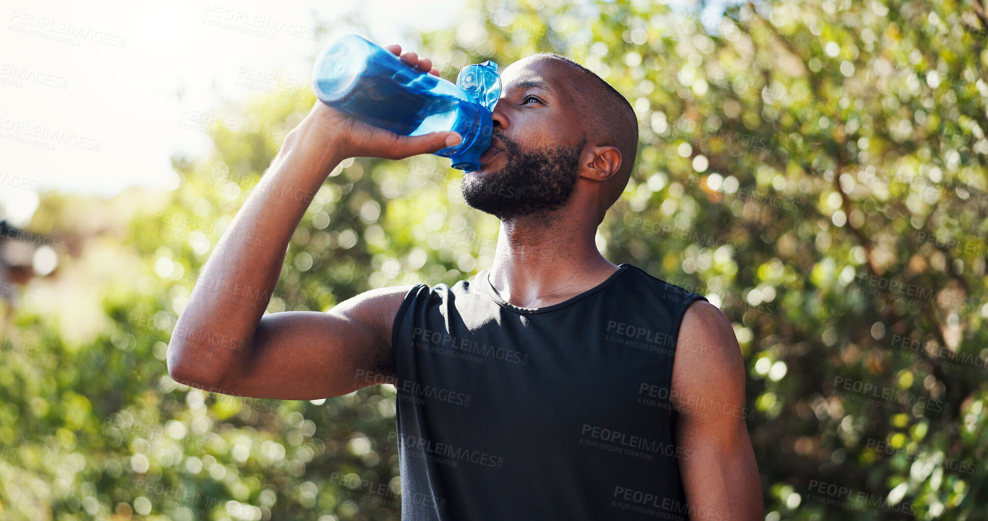 Buy stock photo Black man, bottle and drinking water for running, break and hydration with training, exercise and wellness in summer. Person, outdoor and liquid with workout, fitness and sunshine at park in Nigeria