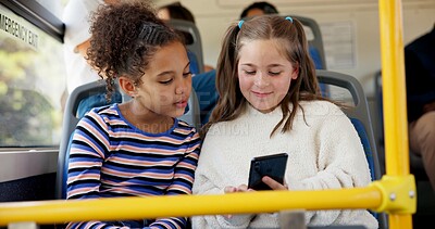 Buy stock photo Children, students and travel on bus with phone for class schedule, online cartoon and educational game. Happy friends, girls and trip on public transport for morning commute and school destination