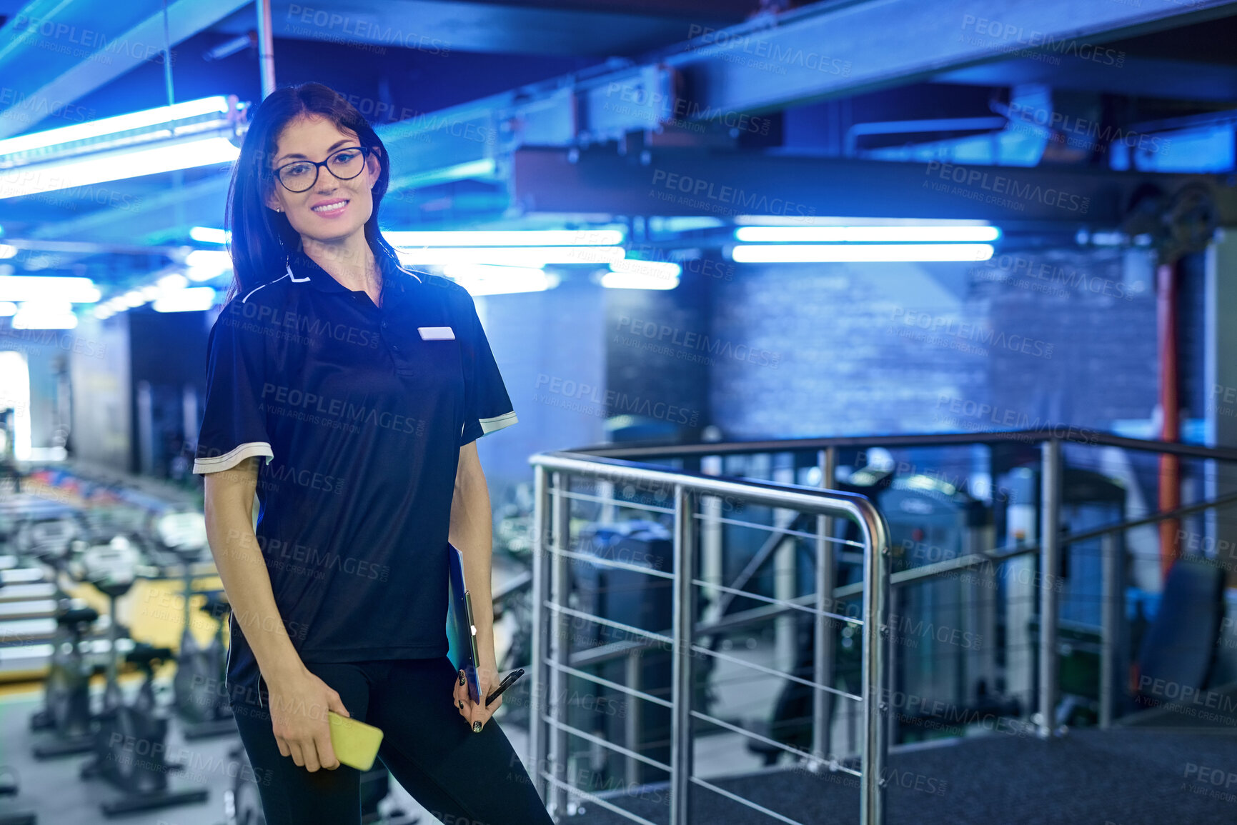 Buy stock photo Portrait, smile and woman in gym for fitness, wellness or body health with phone checklist in Italy. Professional, sports and coach at club, worker or happy personal trainer in glasses for workout