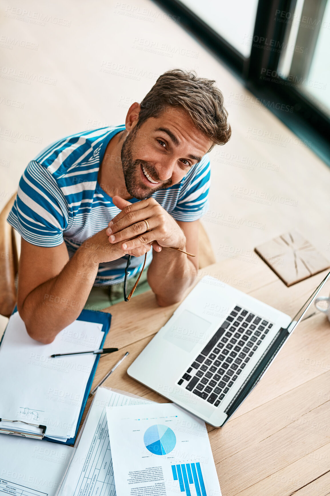 Buy stock photo Man, portrait and above with laptop in home office for work as freelance web or graphic designer. Male person, documents and data report for performance metrics, budget tracking and website progress.